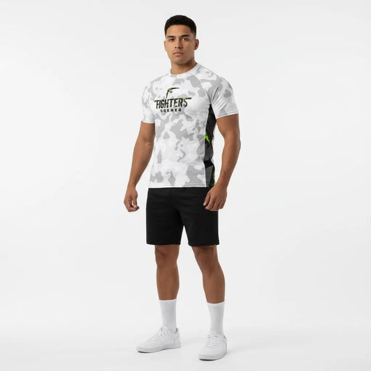 Full-body view of man wearing Arctic Strike boxing compression shirt in white camo with neon accents and black shorts.