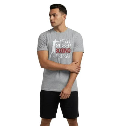 Full-body view of man wearing grey 'Sweat Sleep Boxing Repeat' graphic tee with black shorts