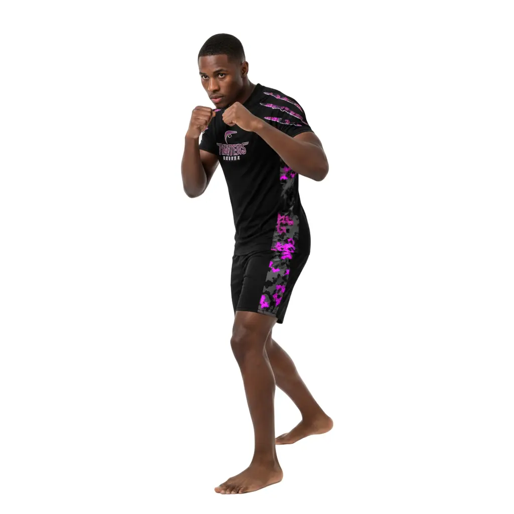 Personin a boxing stance wearing a black athletic outfit with pink camouflage patterns on a white background